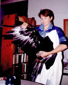 Gillian spreads the bird's wing to show the damage to the outer soaring feathers