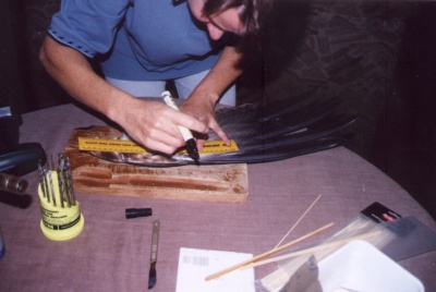 Gil measures the donor feathers prior to cutting them from the wing of a dead eagle